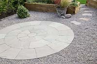 Finished circular patio with stepping stone path surrounded by gravel - Green York