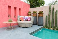 Beneath a Mexican Sky Garden - Inspired by Luis Barragan with colour-washed walls in tints of clementine, coral and concrete slabs across aquamarine pool and seating area with Stenocereus marginatus, Erigeron karvanskianus and Osteospermum '3D Pink'-  RHS Chelsea Flower Show 2017 