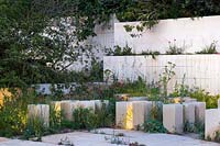 The M and G Garden, view of pillars made of Maltese limestone and garden lighting at night - RHS Chelsea Flower Show