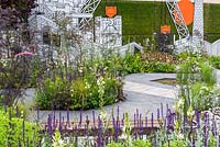 Perennial planting with Salvia against a wall of street art, created by Sheffield urban artist Jo Peel in Greening Grey Britain Garden - RHS Chelsea Flower Show 2017 - 