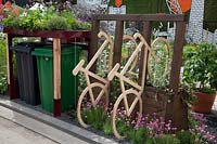 The RHS Greening Grey Britain Garden -  A bin store with living roof and a bike storage rack - RHS Chelsea Flower Show 2017