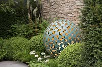 Round sculpture lit from the inside in a bed of box and primulas - RHS Chelsea Flower Show 2017