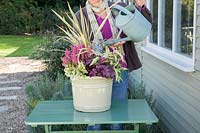Woman watering finished Winter interest container
