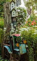 Bird houses in a tree with a bed of Phlox, Petunia and Dahlia 