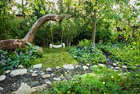 Tree rope swing in wild garden next to the  stream with stones - The Zoflora and Caudwell Children's Wild Garden, RHS Hampton Court Palace Flower Show 2017