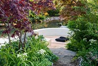 Japanese style garden with sunken circular area with Acer palmatum, Ferns, Aquilegia  'Nora Barlow' and Saxifraga urbinum by large pool - 'At One With...A Meditation Garden' - Howle Hill Nursery, RHS Malvern Spring Festival 2017 
