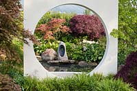 Japanese style garden framed with 'Moongate' window, with sunken circular area with planting of Hakonechloa macra, Acer palmatum, Astilbe, Zantedeschia aethiopica and Gunnera manicata - 'At One With...A Meditation Garden' - Howle Hill Nursery, RHS Malvern Spring Festival 2017