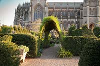 Walled garden with clipped yew hedges and decorative archway with cathedral beyond at Arundel Castle, Sussex in spring. Head Gardener: Martin Duncan