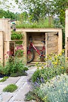 Front garden with bicycle storage with green roof made from recycled wood and stone and gravel surface - BBC Gardener's World Live, Birmingham 2017 - Artemis Landscapes 'Living in Sync' Garden - Designer: Viv Seccombe