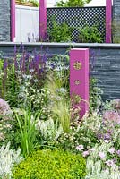 Bug hotel and planting in pink, blue and white with Salvia, Stipa and Allium  in outdoor kitchen with bug hotels, grey stone wall  - BBC Gardener's World Live, Birmingham 2017 - The Lanwarne Landscapes 'Contemporary Bee and Butterfly' Garden - Head Sponsors: IntoUniversity, Big City Bright Future Programme, Black Rock - Best Landscape Construction. Best Construction Landscaper