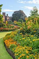 Orange and yellow themed border with rudbeckias, marigolds, tagetes, Lilium henryi and ligularia. The Fellows Garden, Clare College, Cambridge.