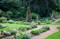 Fountain with wedding-cake tiers and Gothic ornamentation, Palm House beds feature  Eupatorium rugosa 'Chocolate', Canna 'Wyoming', and Aster x frikartii 'Monch'.