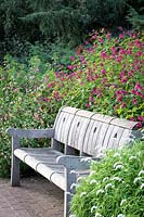 Wooden garden bench in late summer border