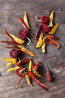 Making a dried chili wreath on wooden background