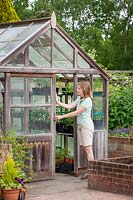 Opening greenhouse door on warmer days for ventilation, May
