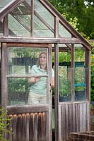 Opening greenhouse door on warmer days for ventilation, May