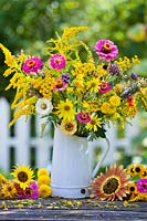 Jug of summer flowers: sunflowers, Zinnias, Verbena bonariensis, Rudbeckia, Solidago, Chrysanthemum and Tanacetum vulgare.