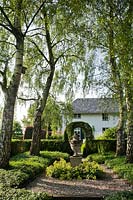 Birch grove with shady plantings and central decorative urn. De Carishof garden, July