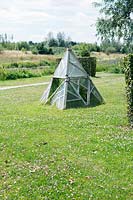 Greenhouse in pyramid shape on lawn, June.