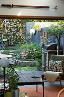 Wide view of inner city courtyard garden with greenwall of succulents and various plantings