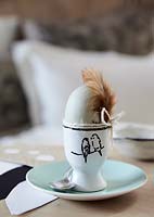 Egg in eggcup with feather