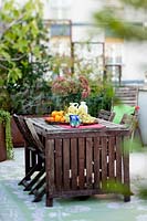 Outdoor table set with fruit surrounded by Garden terrace plants