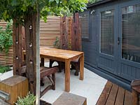 Large reclaimed teak tables and chairs in small garden, September.
