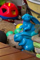 Two blue painted Rabbit ornaments next to the timber decking