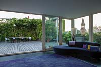 View from inside house to lower terrace with hydrangea and climbing plants. Milan. Italy, May.