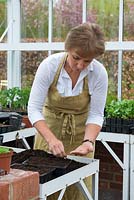 Philippa Burrough planting seed in the greenhouse.
