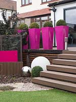 Tall pink planters provide instant impact and stature to the garden. 