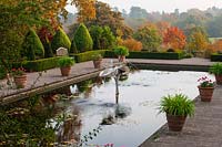 Italian garden with terracotta containers and pool with fountain, Borde Hill Garden, West Sussex, October.