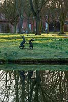 Boxing hares sculpture beside lake, Chippenham Park, Cambridgeshire.