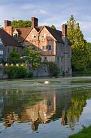 Half timbered tudor wing the house dating from the 1930's seen across moat