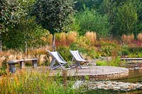 Natural swimming pool with decking, seating and grasses