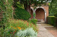 View along path to brick summerhouse with flower border