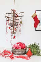Upside down hanging stick Christmas tree with red and white decorations. 