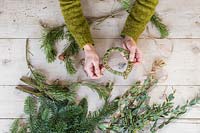 Using string to make a wreath from foliage