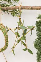 Close up detail of natural material Christmas decorations - branch decorated with stars, wreath and foliage