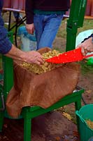 Rack & Cloth Screw Press in use at Community apple juicing day in Sampford Peverell, Devon, late October - loading with apple pulp