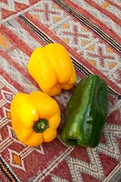 Colourful fresh vegetables - - Yellow and green peppers on a kilim covered table