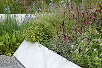 A modern garden planted with Lysimachia atropurpurea 'Beaujolais', Deschampsia cespitosa, Amsonia, Iris. RHS Chelsea Flower Show