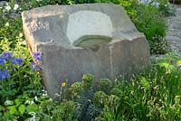 Rough sandstone boulder with bird bath in The M and G Garden, RHS Chelsea Flower Show 2016. Designer Cleve West. Gold Medal winner