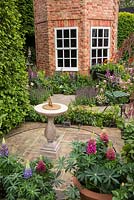 Sundial and patio in The Harrods British Eccentrics Garden, RHS Chelsea Flower Show 2016. Designer Diarmuid Gavin.