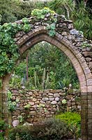 Stone archway to ruined Abbey at Abbey Gardens Tresco Scilly Isles UK