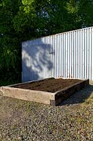 Newly completed raised bed for vegetables made from old railway sleepers and filled with compost