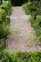 Brick paved path Buxus Taxus small clipped hedge Stipa tenuissima