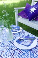Summer scene of table & seat with blue & white decoration for an al fresco meal