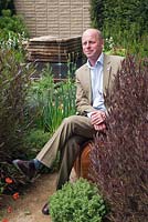 Homebase Teenage Cancer Trust Garden designer Joe Swift sitting in his garden at the RHS Chelsea Flower Show 2012