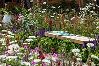 Colorful perennial garden with wooden bench